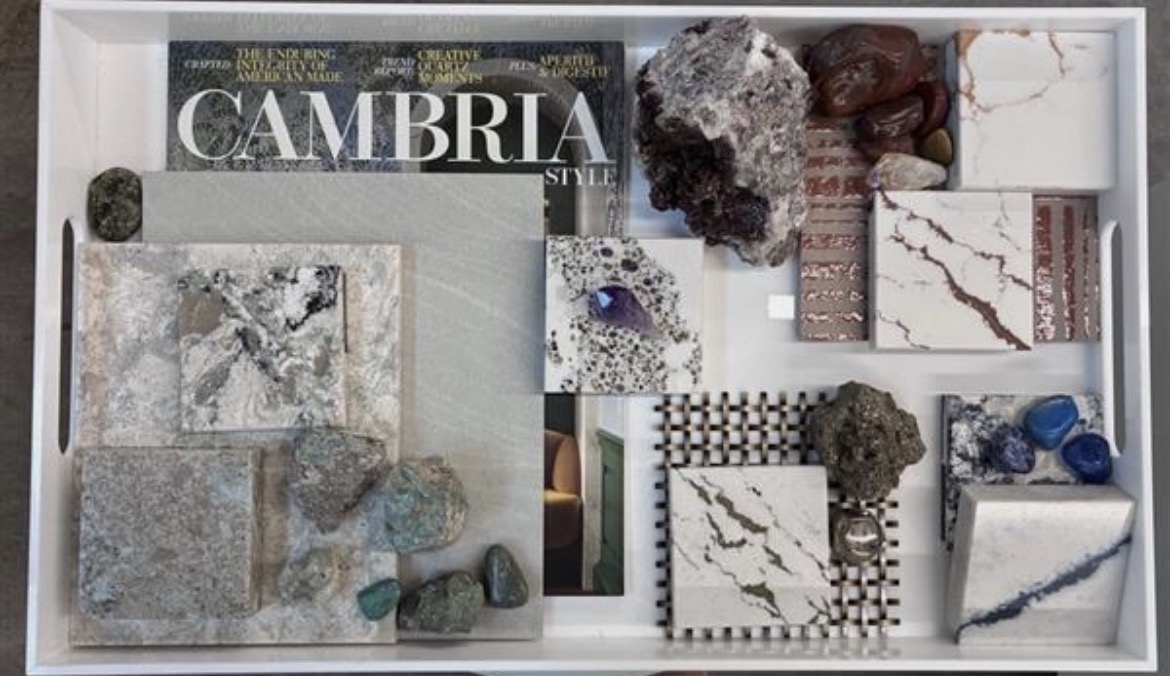 White display tray of stone, quartz and mineral samples arranged around a Cambria Style magazine
